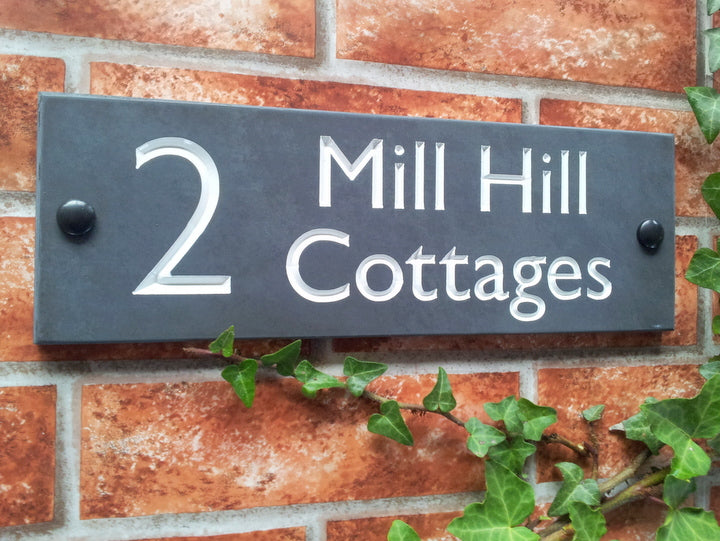 Slate home address sign  300mm x 100mm dispaying the number 2 and the wording Mill Hill Cottages in a white inlay